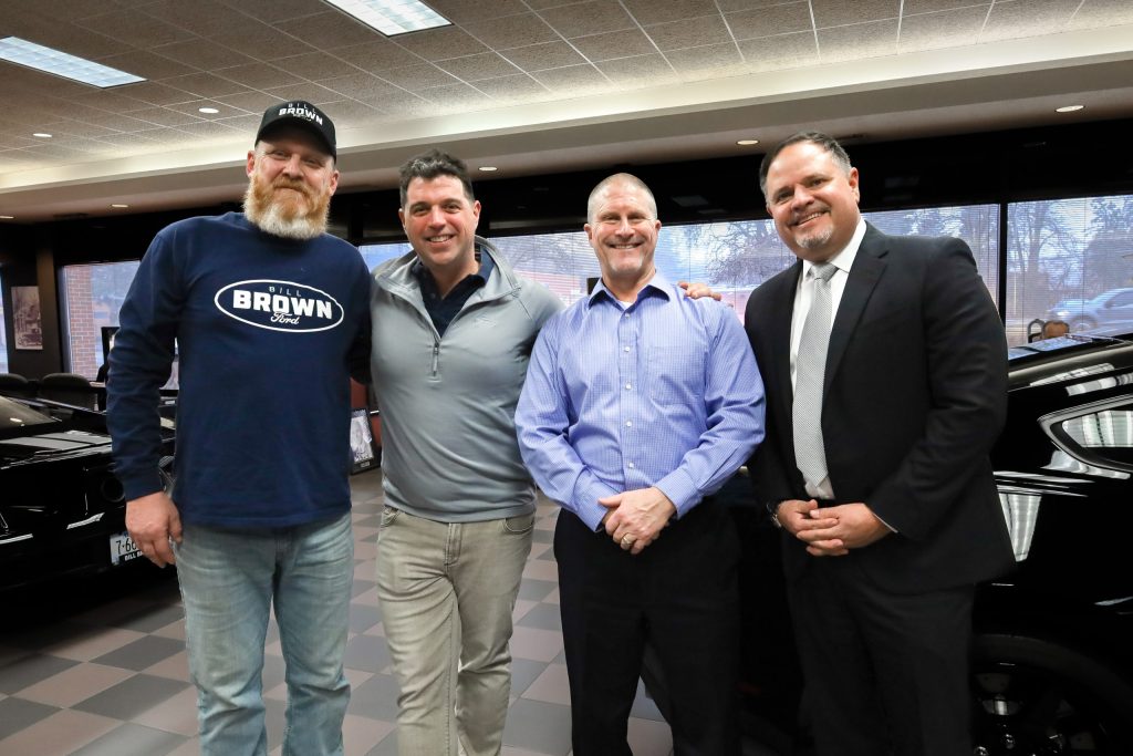 Bill Brown Ford's Dave Bird, Tom, Tashman, Garchow posing for #1 Ford Dealer in the world title